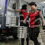 menalar.id,. - Presiden Prabowo Subianto meresmikan 1.179 Satuan Pelayanan Pemenuhan Gizi (SPPG) Polri dan 18 gudang ketahanan pangan Polri di Polsek Palmerah, Jakarta Barat, Jumat (13/2/2026). Mulanya, Prabowo meninjau sejumlah dapur SPPG, kolam bioflok ikan, dan budidaya tanamana hidroponik milik polri. Peresmian 1.179 Dapur MBG Kemudian, Prabowo turut berinteraksi dengan beberapa SPPG Polri di sejumlah daerah. Dalam peresmian tersebut, sejumlah anggota Kabinet Merah Putih hadir, seperti: Menteri Koordinator Pangan Zulkifli Hasan Menteri Koordinator PMK Pratikno Mensesneg Prasetyo Hadi Menteri Kebudayaan Fadli Zon Kepala Badan Gizi Nasional (BGN) Dadan Hindayana Sekretaris Kabinet Teddy Indra Wijaya Kepala Staf Kepresidenan M Qodari, dan Wakil Gubernur DKI Jakarta Rano Karno. Lalu, Kapolri Jenderal Listyo Sigit Prabowo mengungkap pihaknya memiliki target pembangunan SPPG sebanyak 1.500 di seluruh Indonesia pada 2026. Dengan target tersebut, polri kini memiliki peran besar dalam pelaksanaan Makan Bergizi Gratis (MBG). Kemudian, muncul pertanyaan mendasar, bolehkah polri sebagai institusi penegak hukum dapat mengelola SPPG atau dapur umum MBG? Apakah Polri Dapat Mengelola Dapur MBG? Menurut Undang-Undang Pasal 14 Nomor 2 Tahun 2002 polri memiliki tanggung jawab, antara lain: Melaksanakan pengaturan, penjagaan, pengawalan, dan patroli terhadap kegiatan masyarakat dan pemerintah sesuai kebutuhan. Menyelenggarakan segala kegiatan dalam menjamin keamanan, ketertiban, dan kelancaran lalu lintas di jalan. Membina masyarakat untuk meningkatkan partisipasi masyarakat, kesadaran hukum masyarakat serta ketaatan warga masyarakat terhadap hukum dan peraturan perundang-undangan. Turut serta dalam pembinaan hukum nasional. Memelihara ketertiban dan menjamin keamanan umum. Melakukan koordinasi, pengawasan, dan pembinaan teknis terhadap kepolisian khusus, penyidik pegawai negeri sipil, dan bentuk-bentuk pengamanan swakarsa. Melakukan penyelidikan dan penyidikan terhadap semua tindak pidana sesuai dengan hukum acara pidana dan peraturan perundang-undangan lainnya. Menyelenggarakan identifikasi kepolisian, kedokteran kepolisian, laboratorium forensik dan psikologi kepolisian untuk kepentingan tugas kepolisian. Melindungi keselamatan jiwa raga, harta benda, masyarakat, dan lingkungan hidup dari gangguan ketertiban dan/atau bencana termasuk memberikan bantuan dan pertolongan dengan menjunjung tinggi hak asasi manusia. Melayani kepentingan warga masyarakat untuk sementara sebelum ditangani oleh instansi dan/atau pihak yang berwenang. Memberikan pelayanan kepada masyarakat sesuai dengan kepentingannya dalam lingkup tugas kepolisian; sertal. melaksanakan tugas lain sesuai dengan peraturan perundang-undangan. Kemudian, dalam Peraturan Presiden (PP) Pasal 19 ayat (1) Nomor 115 Tahun 2025 tentang Tata Kelola Penyelenggaraan Program MBG menyebut jika BGN dapat bekerja sama denga instansi pemerintah, perseroan terbatas, perseroan perorang, Koperasi, BUM Desa, BUMN, BUMD, atau badan usaha berbadan hukum lainnya. Kemudian juga persekutuan komanditer atau badan usaha tidak berbadan hukum lainnya, usaha mikro, usaha kecil, dan usaha menengah, serta yayasan atau lembaga organisasi atau kemasyarakatan berbadan hukum lainnya. Apabila mengacu pada dua peraturan tersebut, polri tidak melanggar karena hal itu masuk ke dalam pelayanan kepada masyarakat dan mendukung program pemerintah. Meski demikian, hal ini mengkhawatirkan sebab proses pemantauannya sulit dan tertutup. Respons Pakar Direktur Eksekutif Centre for Indonesia Strategic Actions (CISA) Herry Mendrofa turut merespons kekhawatiran tersebut, Ia menjelaskan secara normatif, selain sebagai intervensi gizi, program MBG juga mendorong partisipasi UMKM, koperasi, dan kelompok masyarakat desa. "Ketika aktor politik lokal menjadi pelaksana langsung, terjadi deviasi fungsi yang mana dari pengawasan menjadi eksekusi. Ini bertentangan dengan prinsip separation of roles dalam tata kelola publik," tegasnya, Selasa (16/9/2025) melansir dari Inilah.com. Ia menilai apabila ada dominasi dari instansi hukum dan elite politik semacam ini, maka berisiko menciptakan rent-seeking behavior. Maksudnya, keputusan alokasi tidak lagi berbasis efisiensi atau keadilan, melainkan kepentingan pribadi atau kelompok. "Akibatnya dapat menghambat inklusi UMKM dan melemahkan efek ekonomi berganda, yang seharusnya dihasilkan oleh program MBG," pungkas Herry. Konflik Dapur MBG Milik Polri Sebelumnya, sejumlah masyarakat melaporkan jika polri melakukan "pencaplokan" kuota ke sekolah-sekolah yang sudah bekerja sama dengan dapur MBG yang masyarakat kelola. Dapur MBG yang masyarakat kelola beralasan pihaknya harus mencari sekolah lain dengan jarak tempuh lebih jauh. Menanggapi hal tersebut, Wakil Ketua Komisi IX DPR RI Yahya Zaini membenarkan hal tersebut. "Jadi SPPG yang sudah kerja sama dengan sekolah, ini disuruh pindah oleh polisi. Ini banyak kasus-kasus ini, Pak. Ini yang melaporkan ke saya itu di Grobogan dan Brebes," ucap Yahya. Beberapa hari kemudian, Yahya memberi klarifikasi sekaligus menyampaikan permintaan maaf kepada pihak Polri. Ia menilai, sikap Polri tak bukan karena kondisi dapur MBG Polri jauh lebih layak dan dapat menjadi contoh. "Pernyataan saya di rapat Komisi IX pada RDP bersama BGN sebelumnya saya luruskan. Saya memohon maaf kepada polri atas kekeliruan tersebut. SPPG Polri terbukti memiliki standar yang back dan menjadi mitra yang dapat diandalkan," Sambungnya. Yahya memuji dapur MBG Polri yang memiliki standar baik, mulai dari bangunan permanen, peralatan dapur lengkap, hingga kendaraan distribusi sendiri.